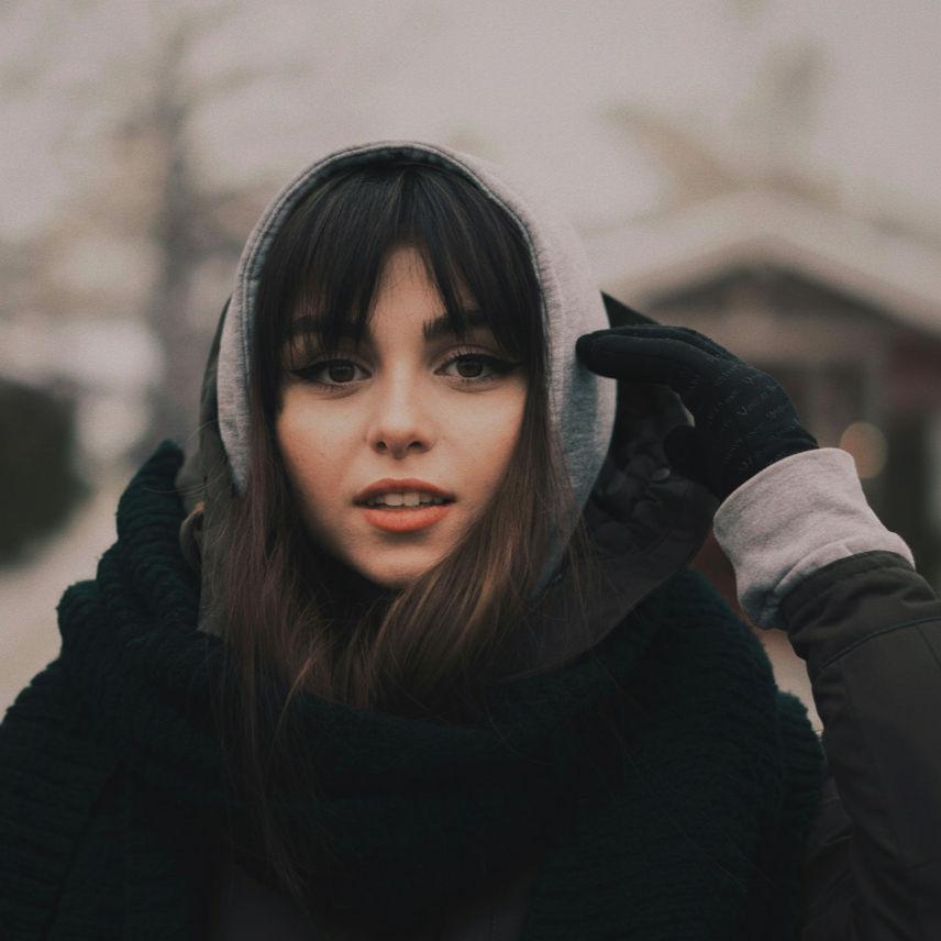 A woman's face beams with joy as she wears Feather Women's Lightweight Heated Gloves in winter.
