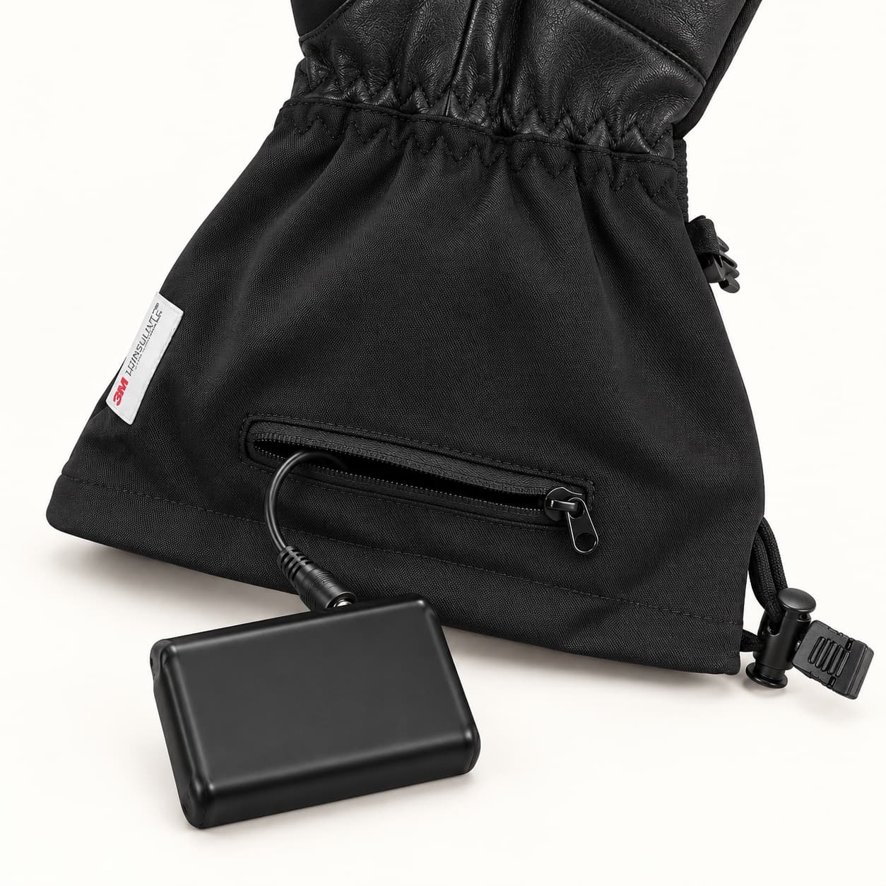 Crab Claw glove cuff with an open zippered battery pocket and a cable connected to the battery beside the cuff.