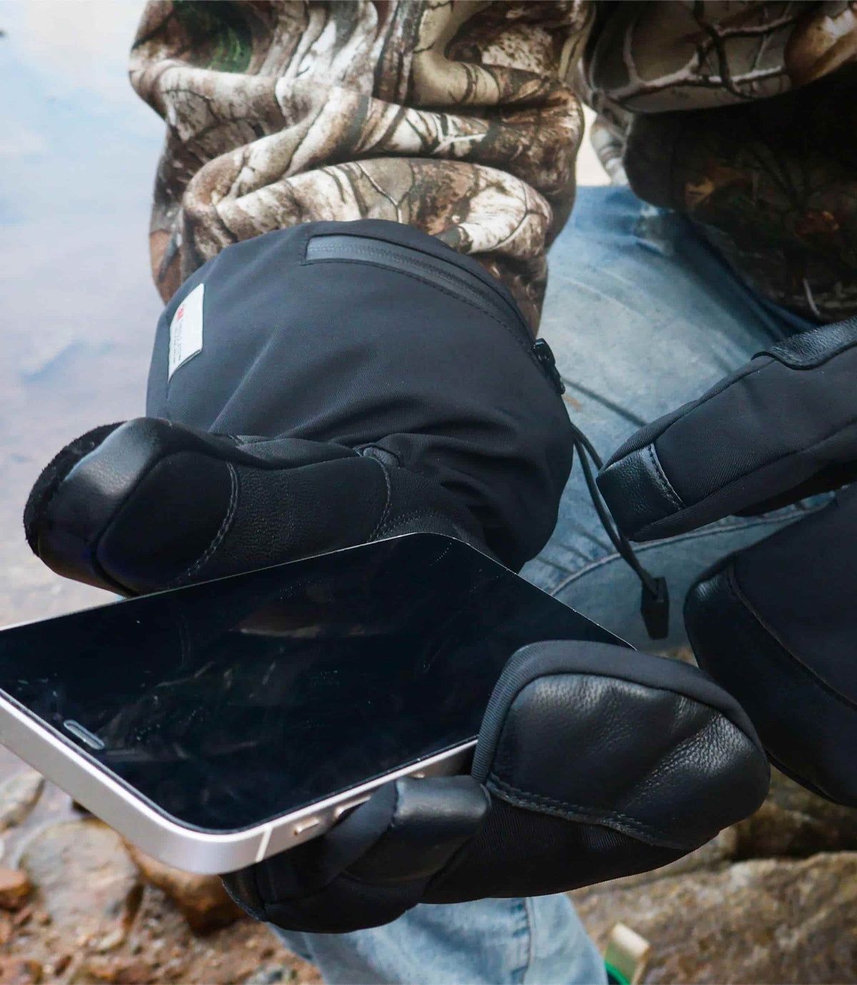 Outdoor user using a smartphone with the touchscreen thumb of Crab Claw heated lobster gloves