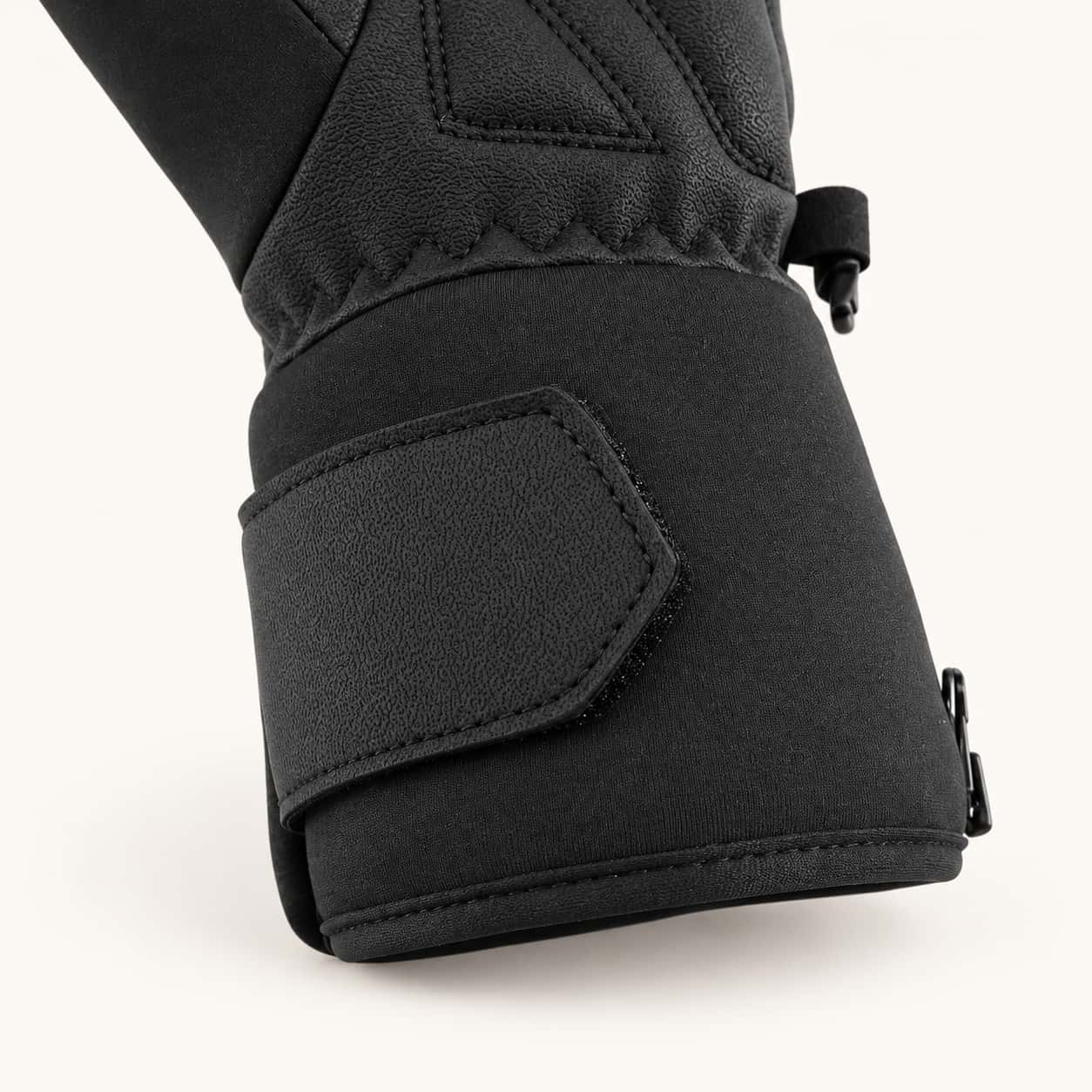 Close-up of an Ember 2.0 glove cuff showing the hook-and-loop strap, stitched edge and side zipper.