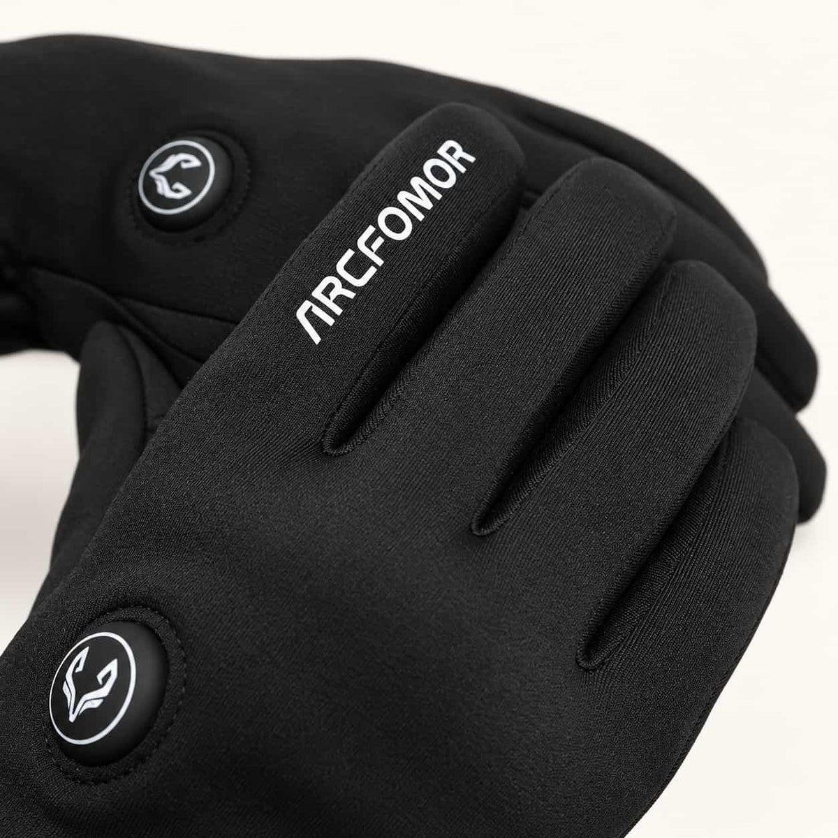 Close-up of Feather glove backs showing the index finger wordmark and round heat control buttons.