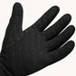 Palm of a Feather heated glove showing the patterned silicone grip and touchscreen pads on the thumb and index finger.