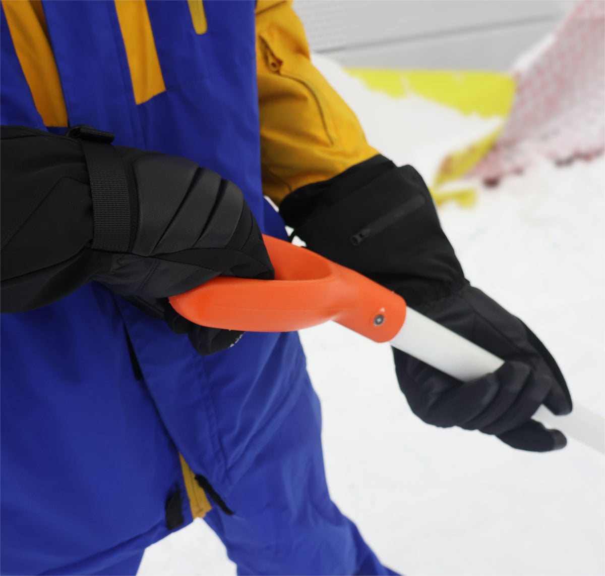 Helm heated outdoor gloves gripping a snow shovel during winter outdoor work