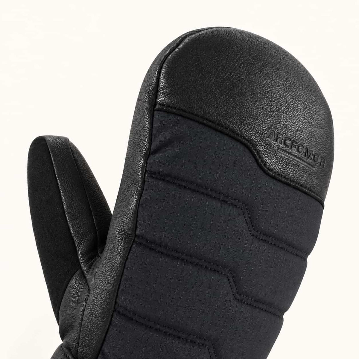 Close-up of a Niagara Stone mitten showing the goatskin fingertip cap, quilted fabric back and embossed ARCFOMOR logo.