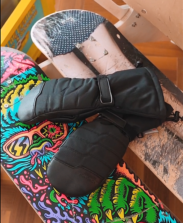 Niagara Stone heated mittens placed with recreational snowboard gear