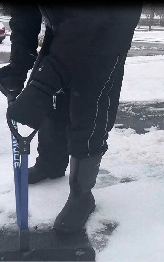 Person wearing Niagara Stone heated mittens while shoveling snow outdoors