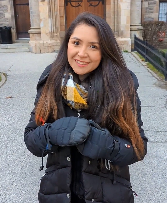 Person wearing Niagara Stone heated mittens during a cold-weather city walk