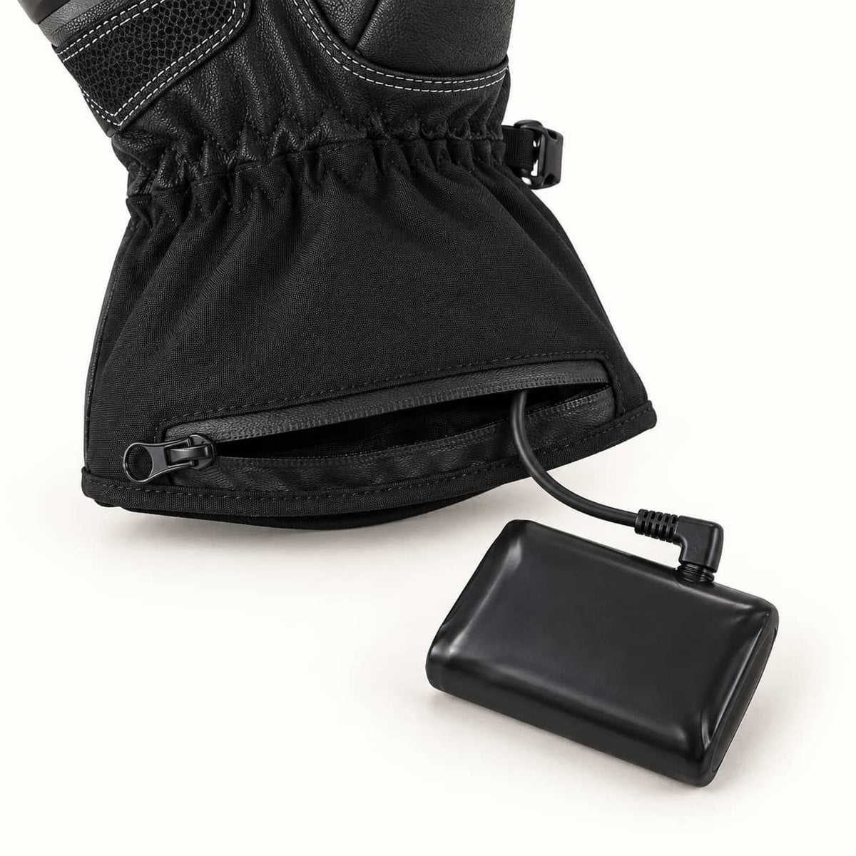 Onyx glove cuff with an open zippered battery pocket and a single cable connected to a black battery beside it.