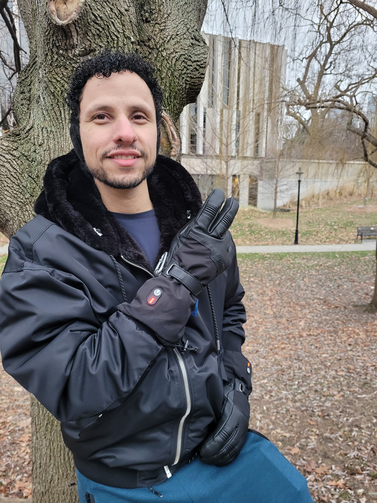 Man wearing Ottawa Nights heated gloves in a winter park with the heat indicators on