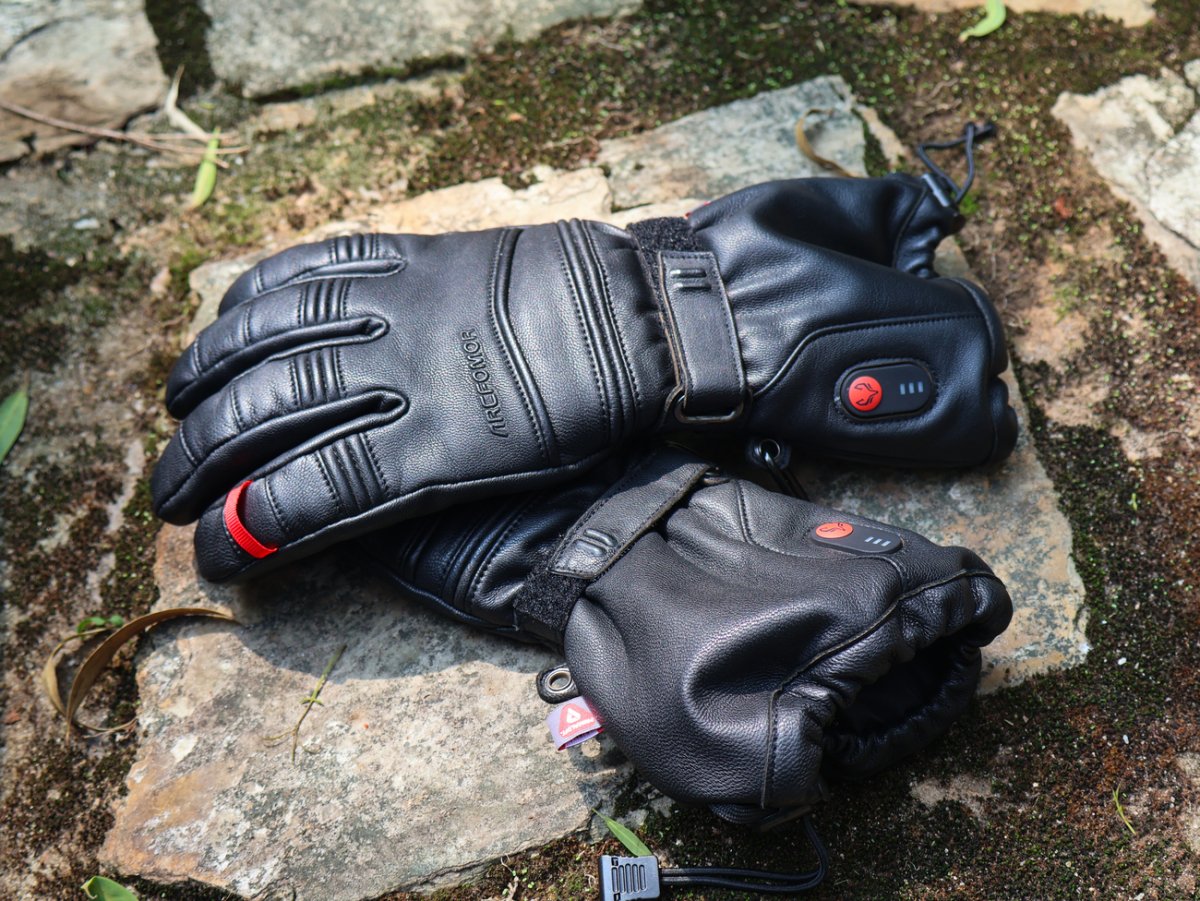 Pair of Polar Baron goatskin heated gloves placed on a rock during an outdoor break