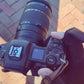 Photographer adjusting camera controls while wearing Spider Silk flip-top heated gloves