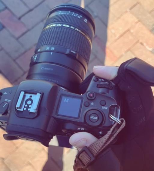 Photographer adjusting camera controls while wearing Spider Silk flip-top heated gloves