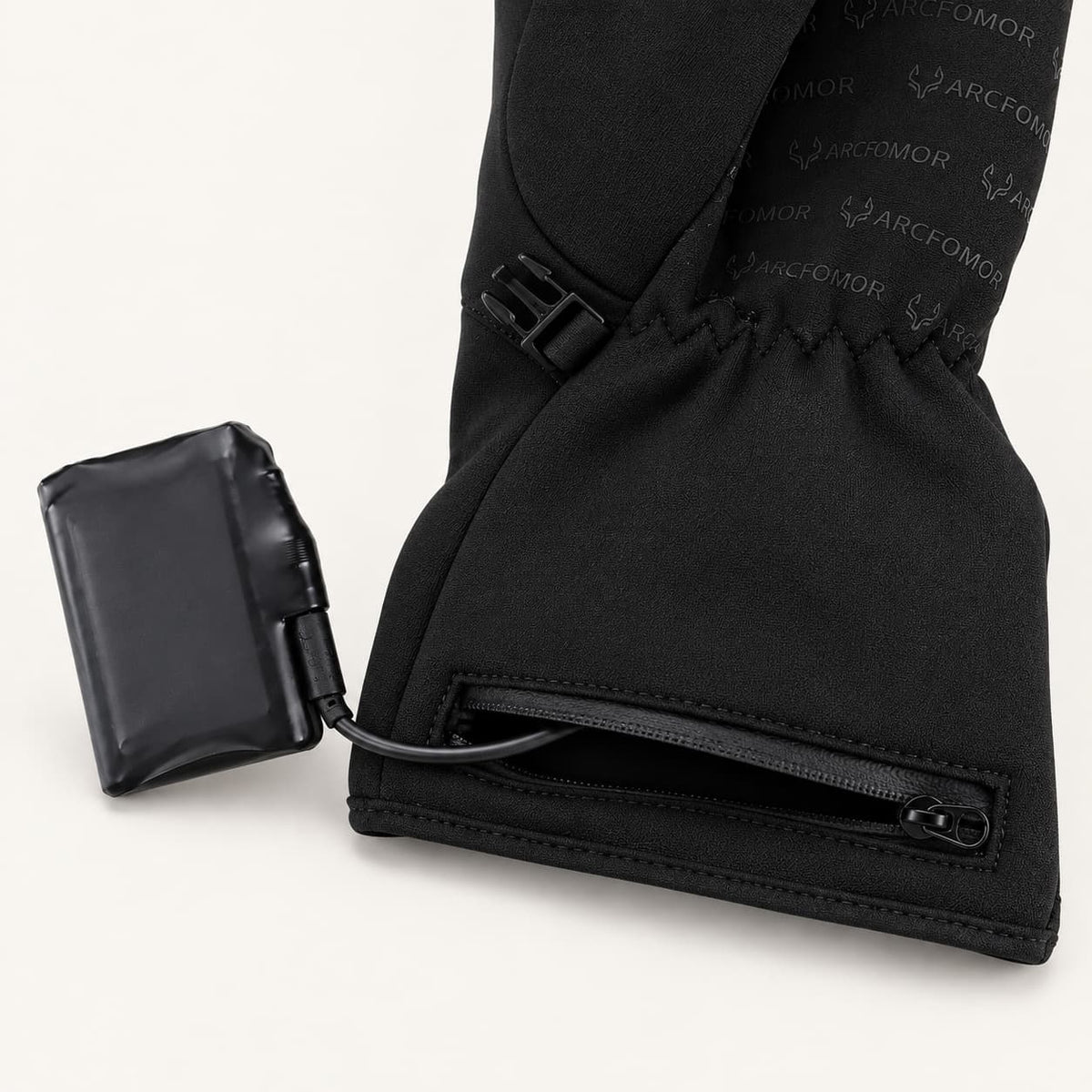Spider Silk glove with its rechargeable battery connected beside the open cuff battery pocket.