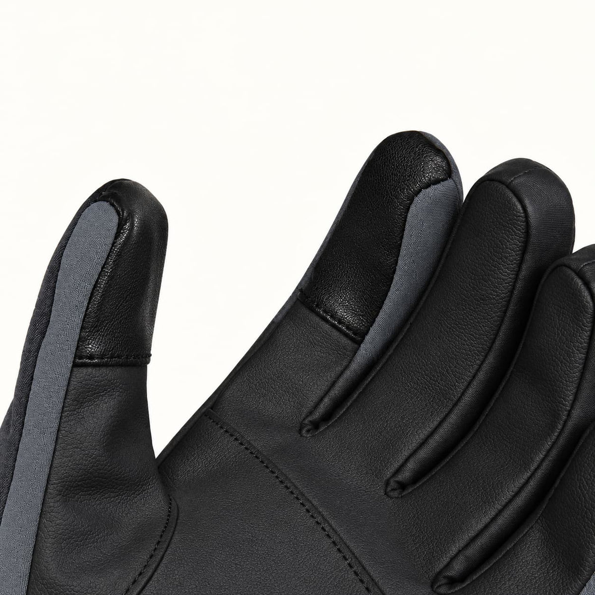 Close-up of a Kunlun glove’s black PU palm, showing the stitched touchscreen patches on the thumb and index fingertip.