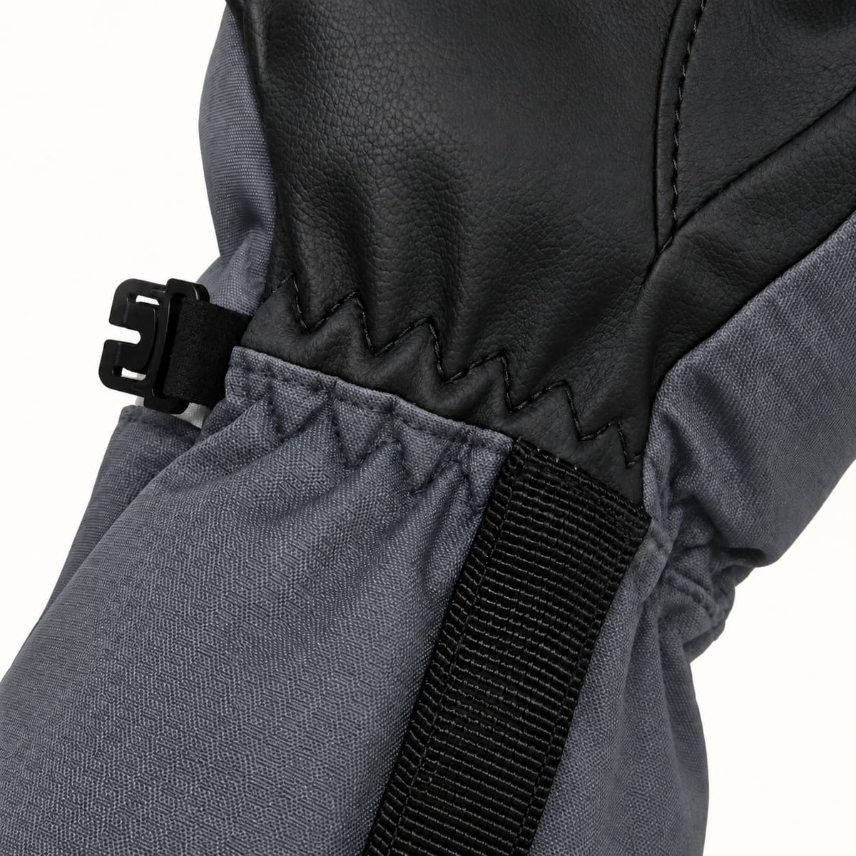 Close-up of the zigzag seam between a Kunlun glove’s black PU palm and gray fabric cuff, with black webbing and a side pairing clip.