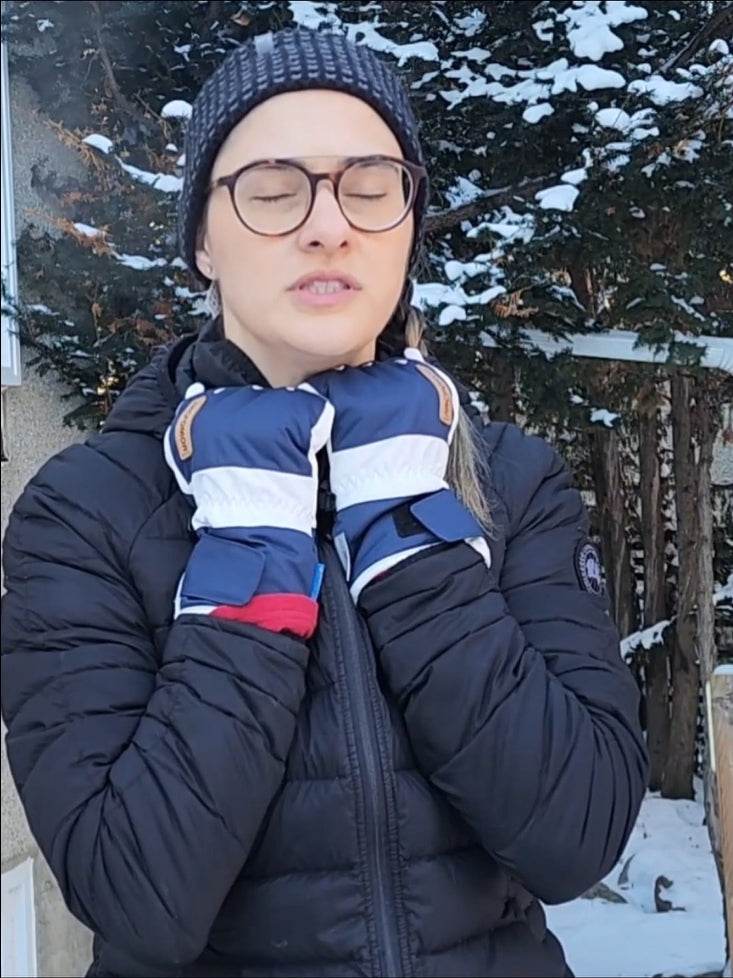 Woman wearing white and navy Summit of Kunlun shell gloves outdoors in snowy weather