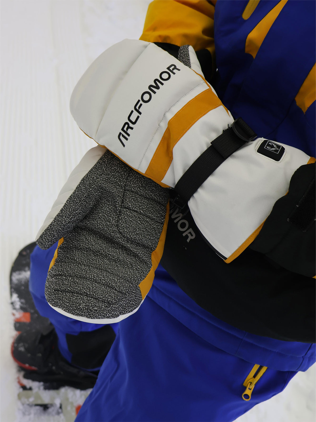 Snowboarder displaying the Kevlar palms of white Toboggan heated mittens