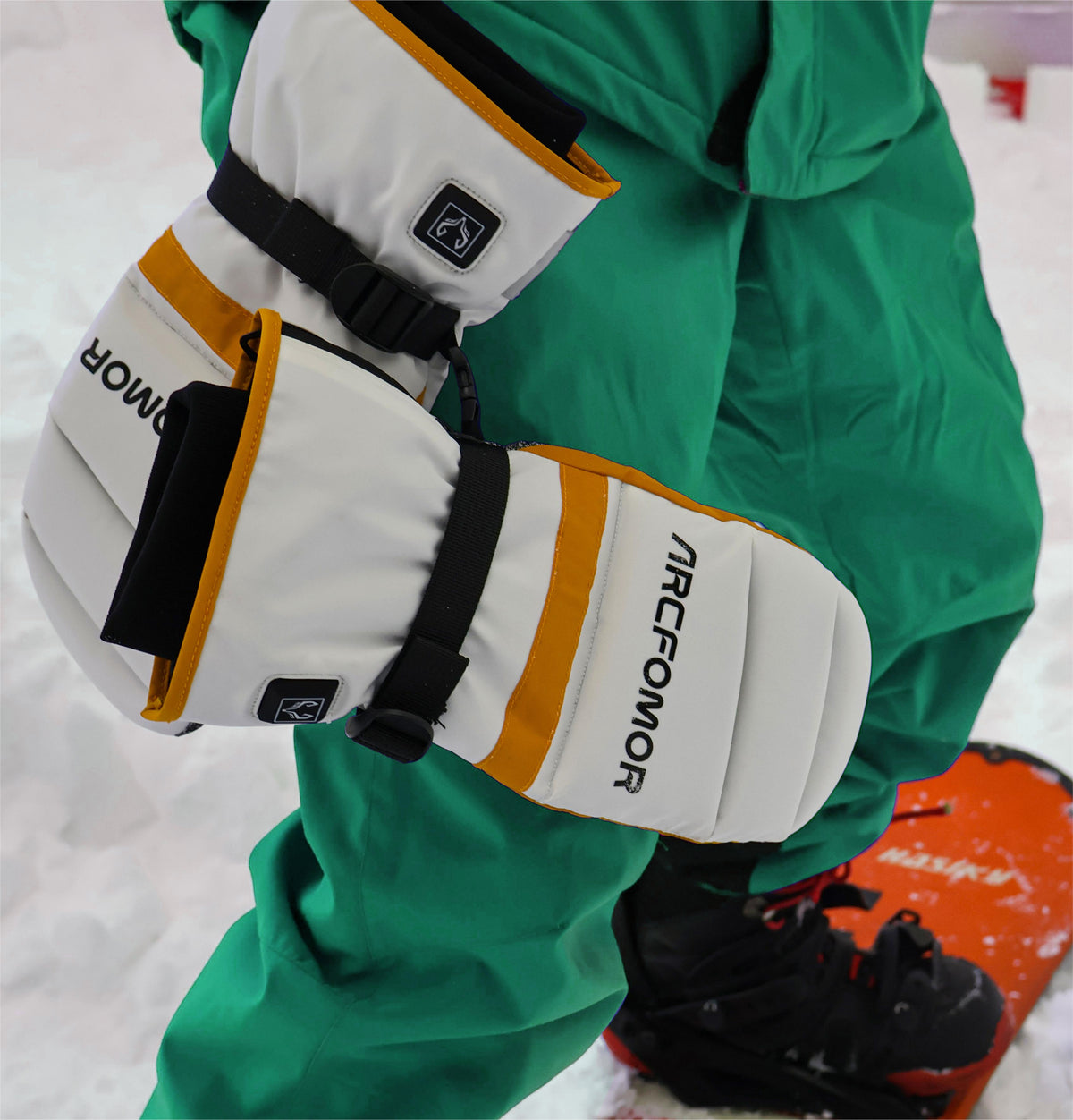 Snowboarder wearing white Toboggan heated mittens in the snow