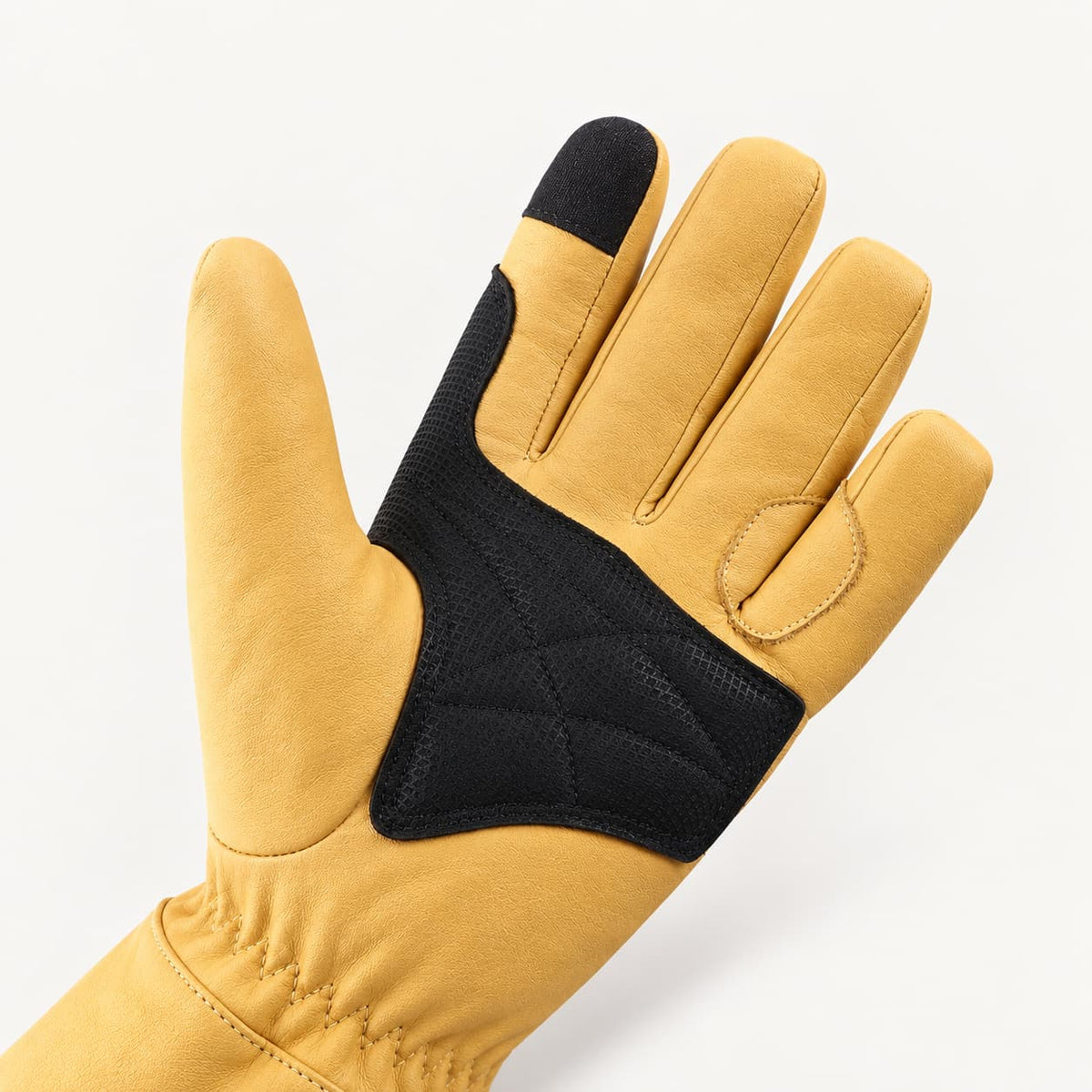 Palm of a yellow Vellum 2.0 glove showing black reinforcement, stitched thumb construction and a touchscreen index fingertip.