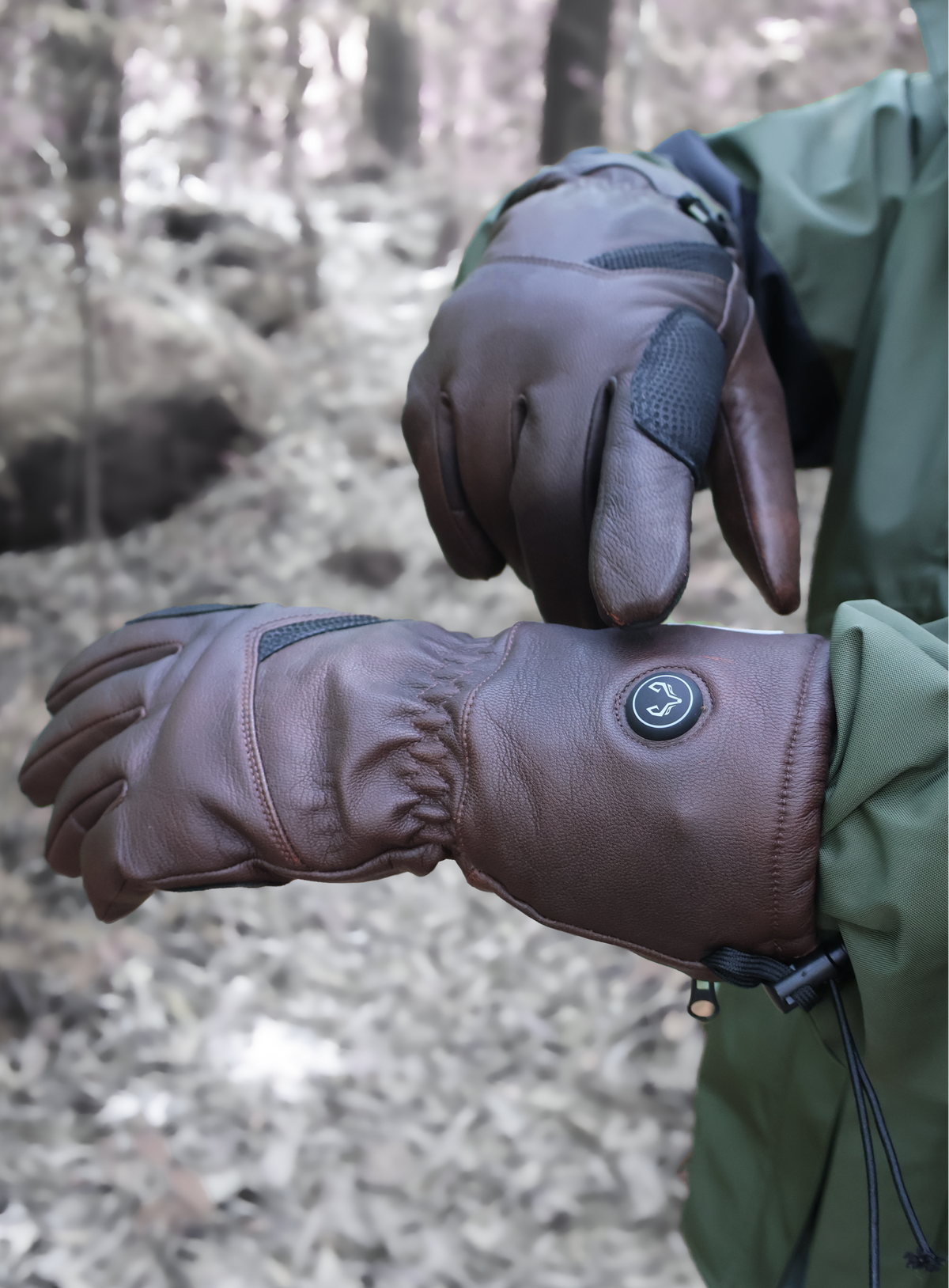 Brown Vellum heated gloves worn outdoors with the heat control button visible