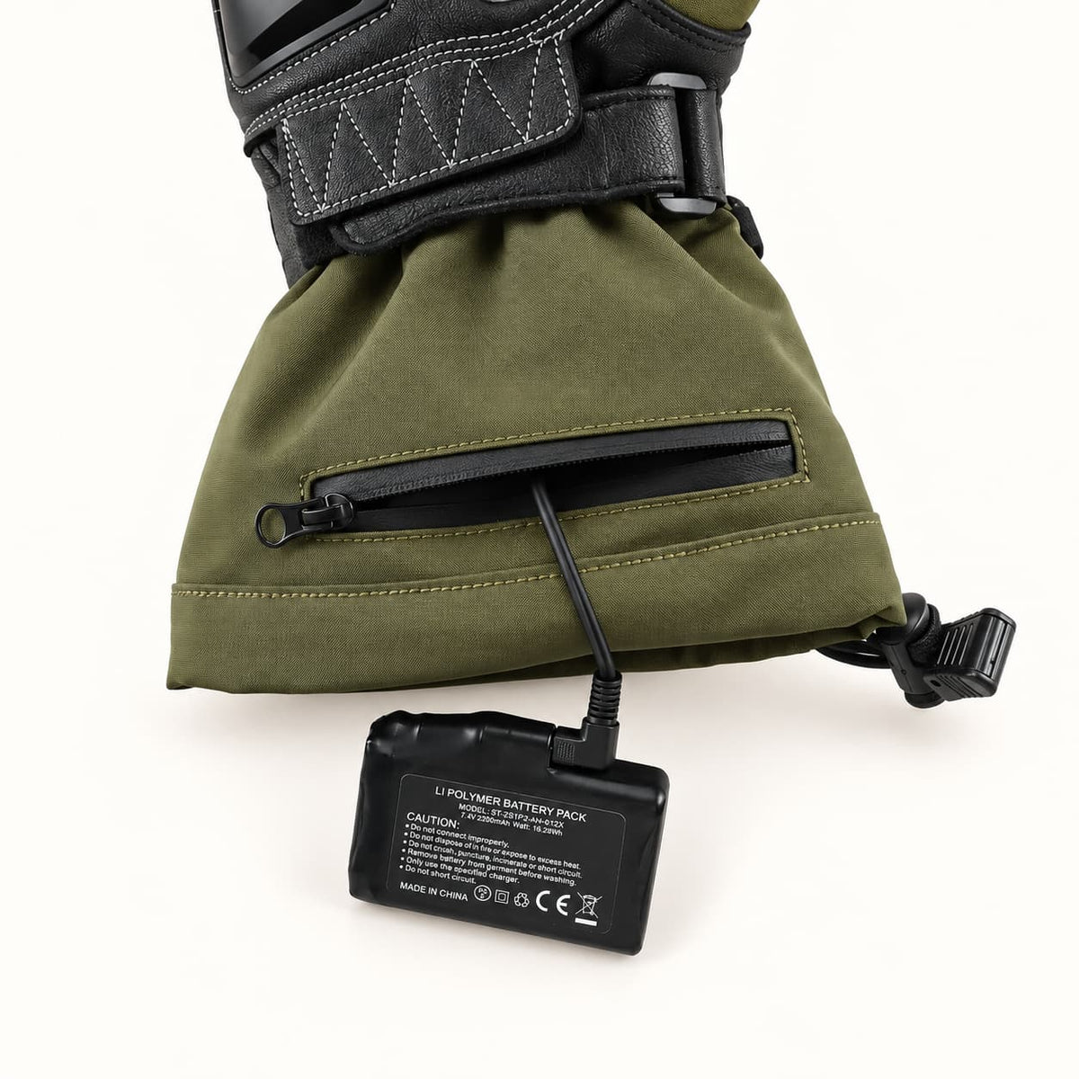 Vortex glove battery connected by a right-angle plug through the open horizontal cuff zipper.