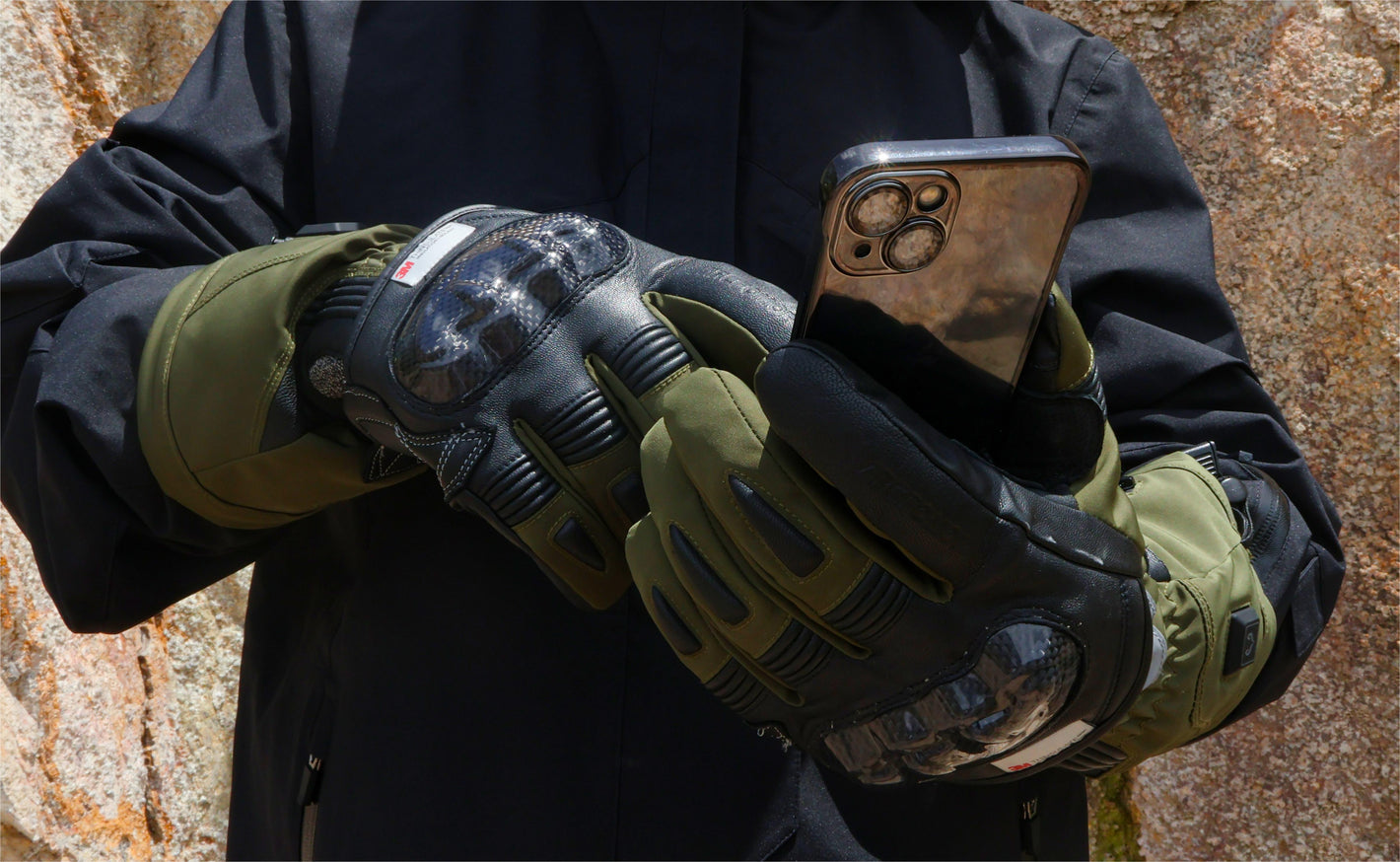 Close-up of Vortex heated motorcycle gloves operating a smartphone