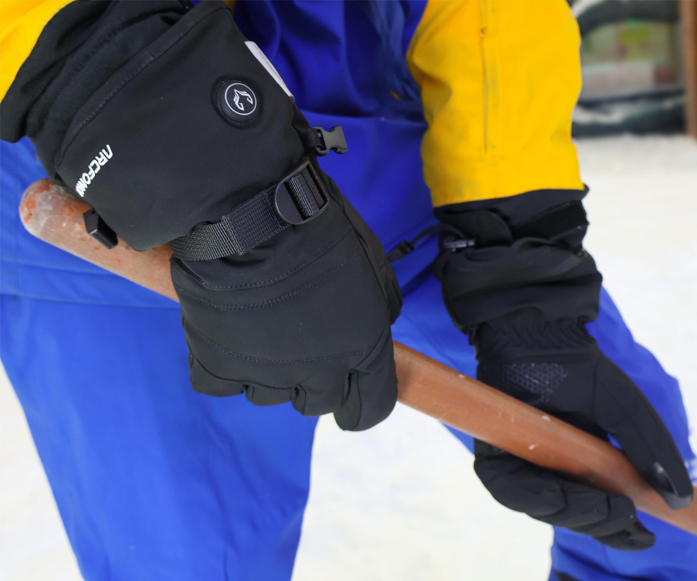 WinterGlow heated gloves gripping a snow shovel handle