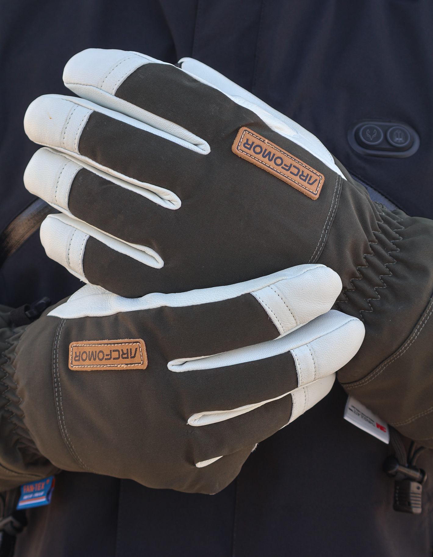Army-green Yellowstone shell gloves worn together showing the touchscreen fingertip panels and extended cuffs