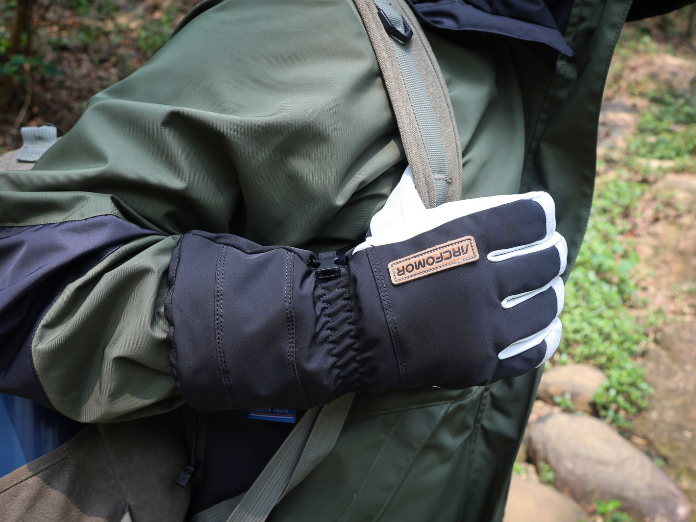 Black Yellowstone shell gloves worn with an outdoor jacket and backpack