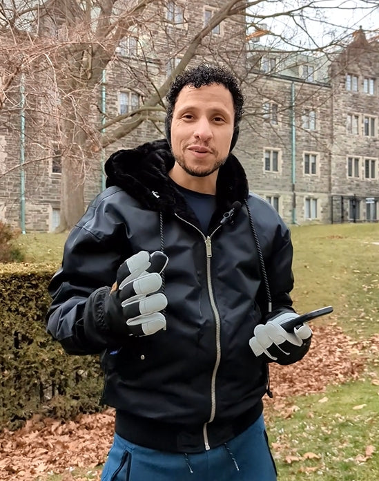 Person using a smartphone outdoors while wearing black Yellowstone shell gloves