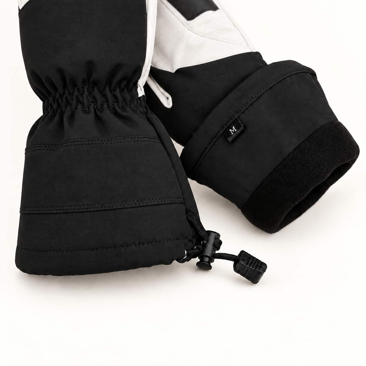Yellowstone glove cuffs showing the black drawcord and toggle alongside a folded cuff revealing its black inner lining.